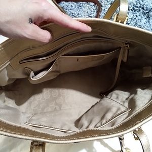 Michael kors medium tote bag that is gold color .
